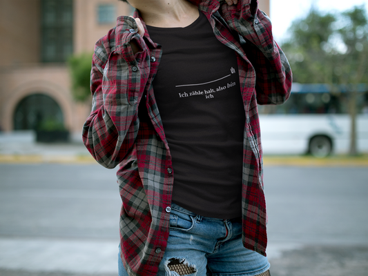 Person wearing a black t-shirt with text and a red plaid shirt over shoulders outdoors.