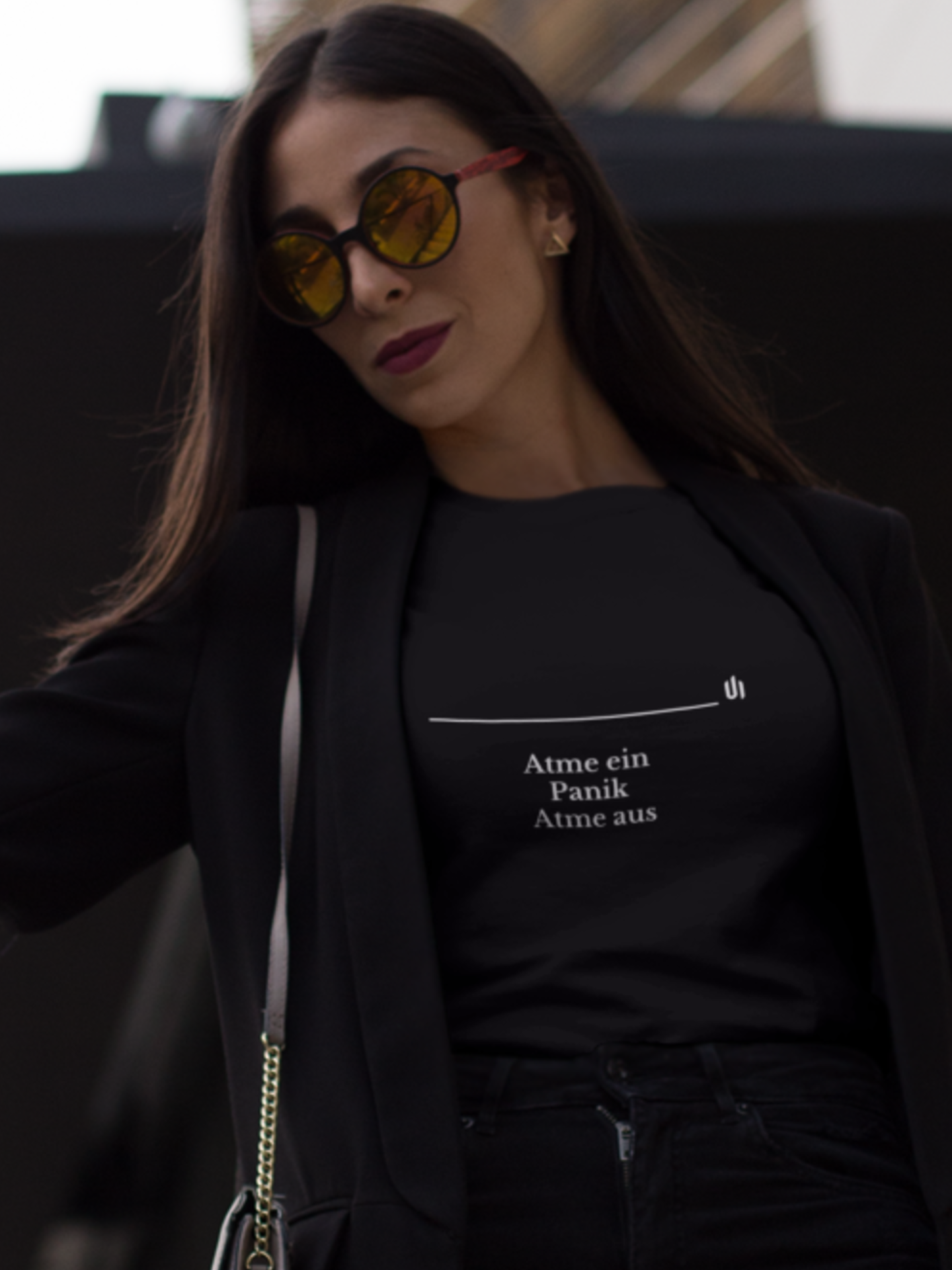 Woman wearing a black t-shirt with text, standing against a dark background
